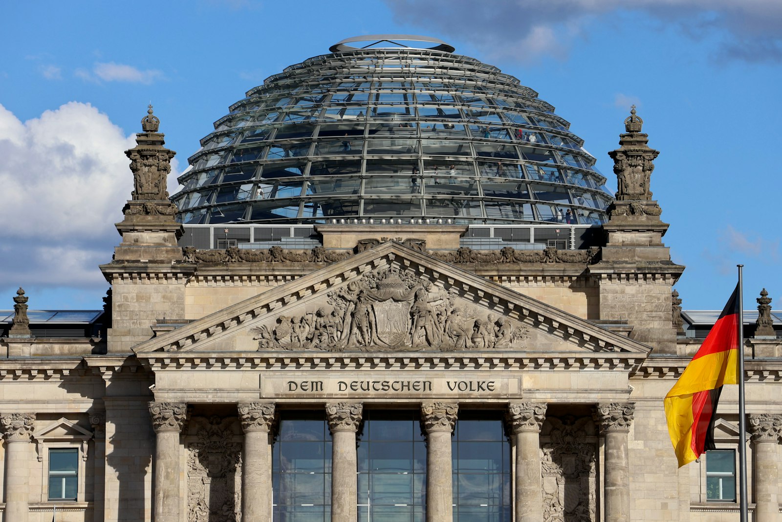 Reichstagsgebäude mit Kuppel und Deutschlandflagge in Berlin